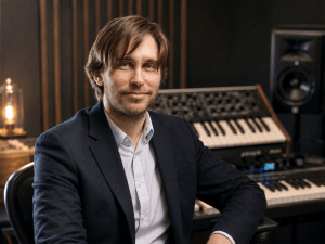 Iyar Stav in a music studio with a synthesizer